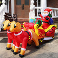 Santa in a red sleigh pulled by two reindeer inflatable in front of a porch