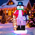 Snowman inflatable in a blue top hat holding a lantern beside a holiday signpost in the snow