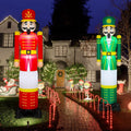Red and green nutcracker inflatables flanking a path lined with candy cane lights
