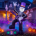 Skeleton in a purple top hat playing guitar with a foot on a boombox inflatable at night