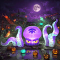 Purple octopus head and two tentacle inflatables glowing among pumpkins at night